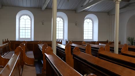 vista de rastreamento ao longo de fileiras de bancos de madeira vintage na antiga igreja luterana