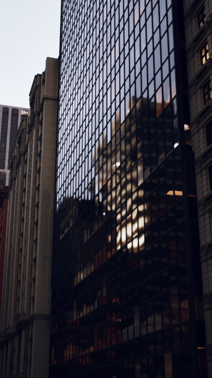 Dark glass structures reflect surrounding buildings and fading evening light