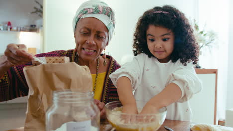 abuela feliz enseñando a la niña a hornear