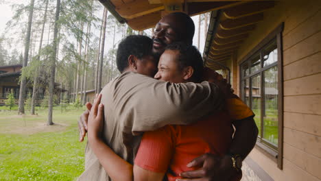 Happy-Woman-Visiting-Her-Family-And-Embracing-Them-Outside-Home