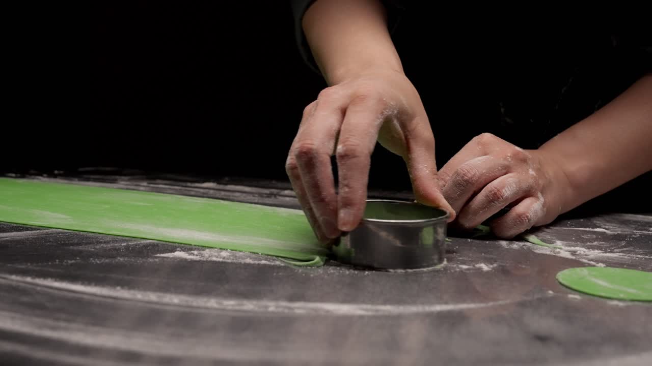 Chef's Hands Cutting Green Dough with a Round Cutter