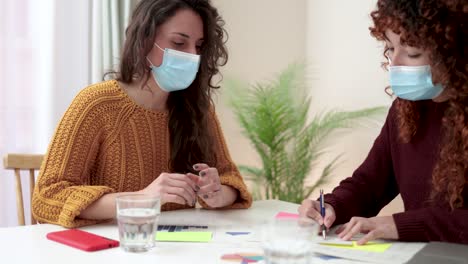 jóvenes empresarios que trabajan dentro de oficinas modernas usando máscaras de protección durante el brote de coronavirus