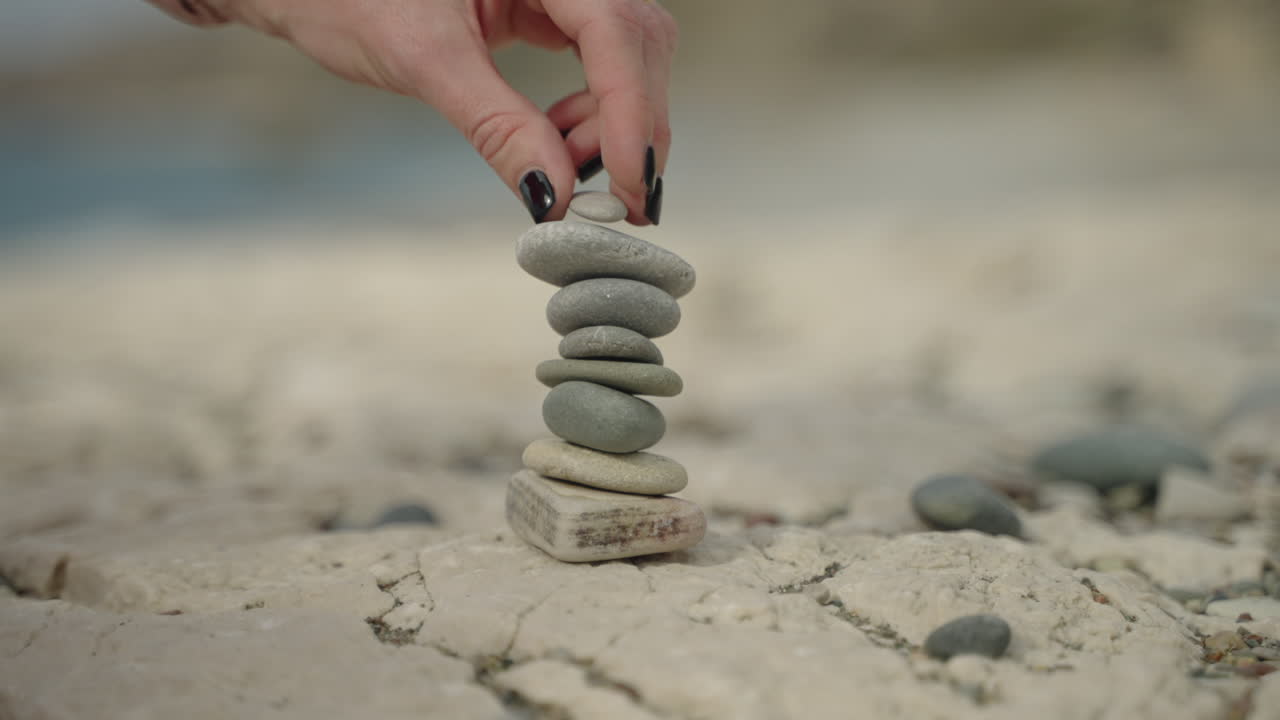 해변에 작은 돌 형성 소녀 손