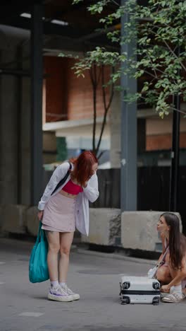 two young women carrying luggage