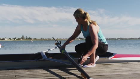 senior caucasian woman preparing rowing boat in a river