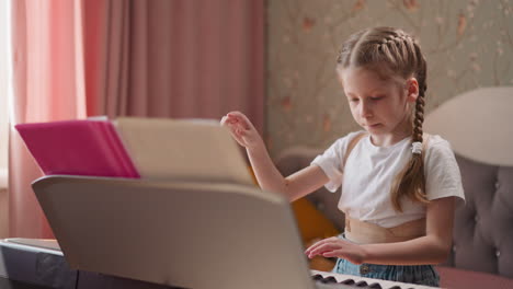 girl flips through pages with notes practicing piano at home