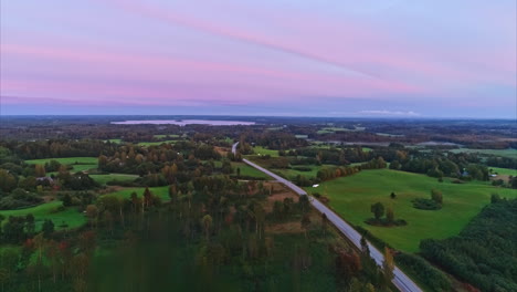 high aerial footage of a green landscape cut in half by a highway