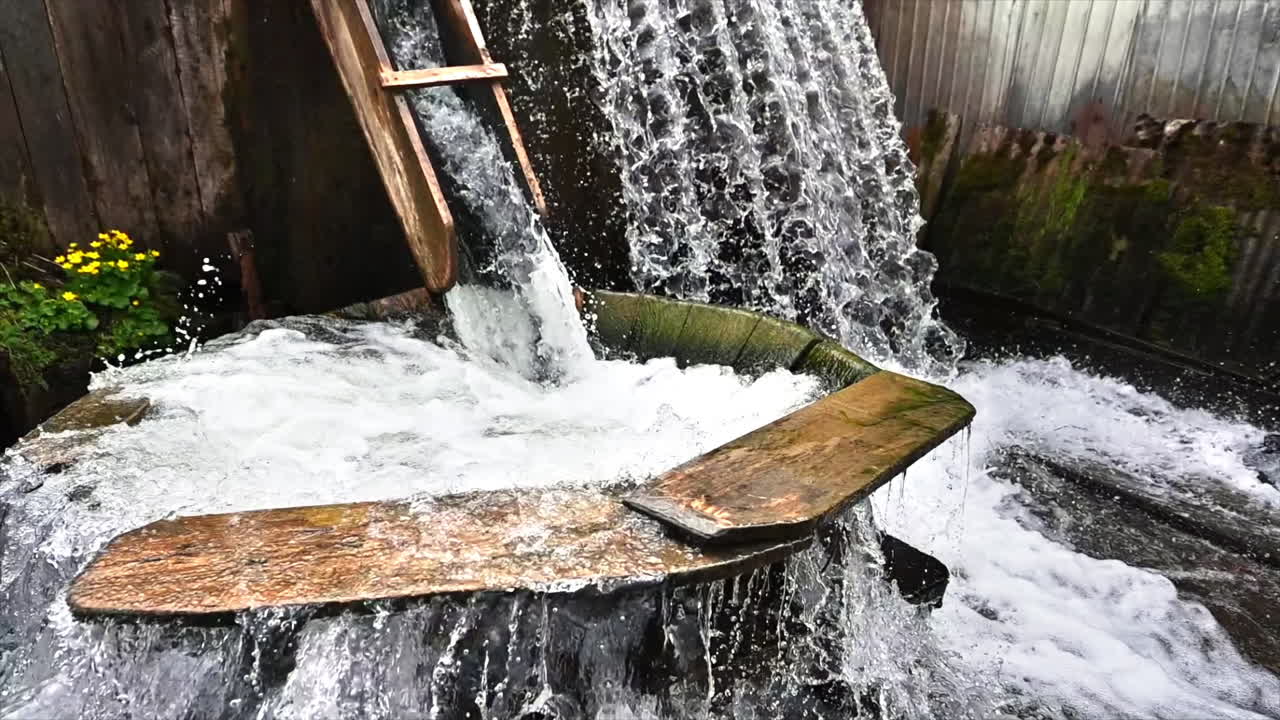 Meccanismo tradizionale per lavare i vestiti sotto l'acqua corrente in un monastero, Romania. Movimento al rallentatore