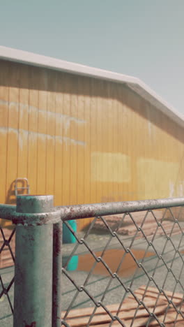 rusty chain link fence with a yellow building in the background