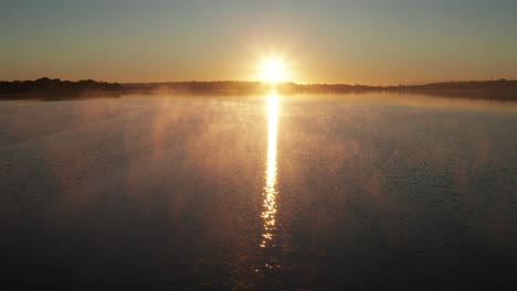 Golden-Sunrise-Reflecting-On-The-Calm-Water-With-Birds-Flying-On-A-Cold-And-Freezing-Morning-In-Auckland,-New-Zealand