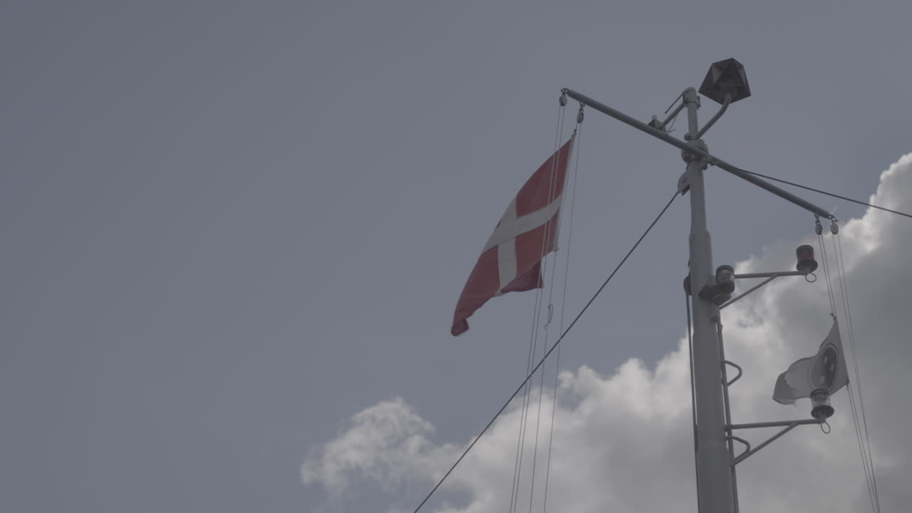 Danish flag waving in the wind in slowmotion hanging from a boat in Copenhagen Denmarkt LOG