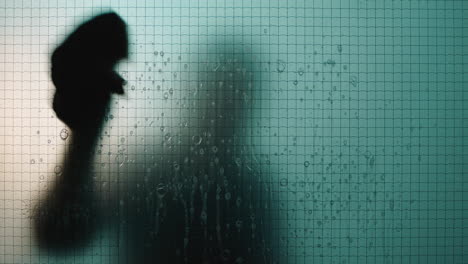 person-cleaning-window-with-water-and-soap-janitor-silhouette