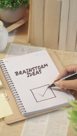 vertical video of ticking off brainstorm ideas from checklist