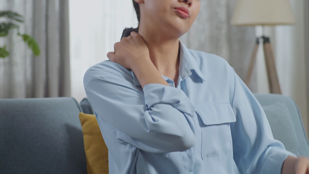 소파에 앉아 누워있는 아시아 여성이 거실로 걸어가고 있습니다.