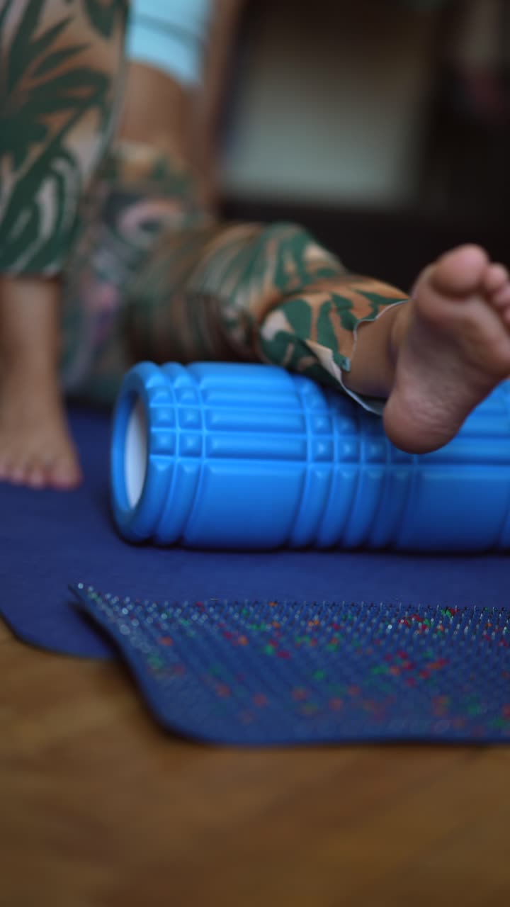 mujer estirando la pierna en un rodillo de espuma