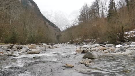 Statische-Weitwinkelansicht-Des-Natürlichen-Flusses,-Der-Mit-Bergen-Und-Bäumen-Im-Hintergrund-Fließt