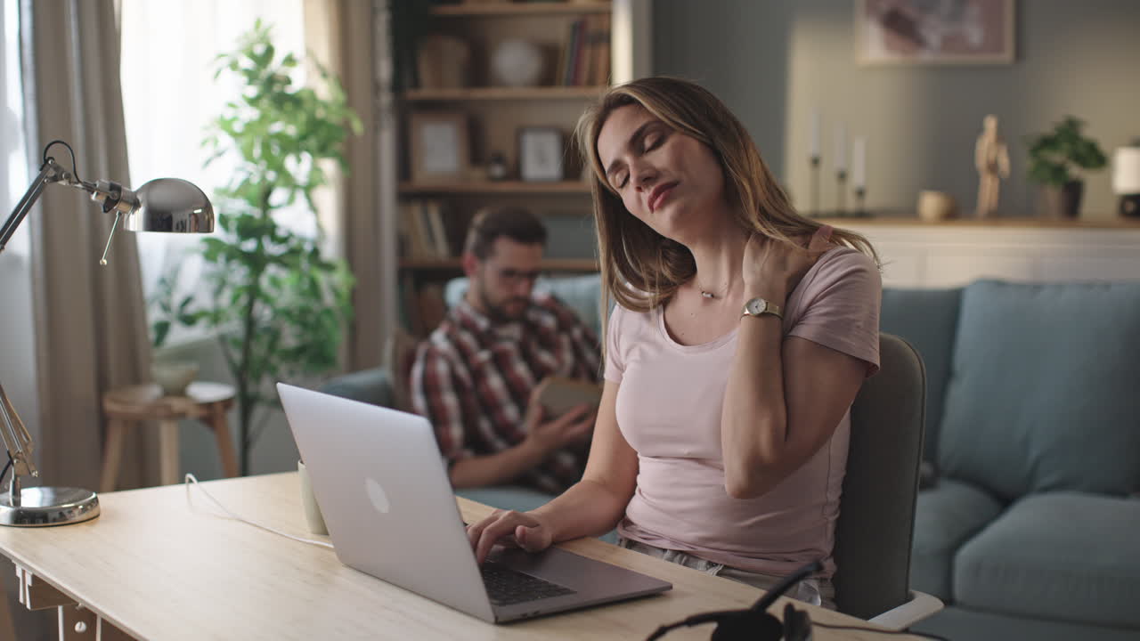 Woman with neck pain working from home