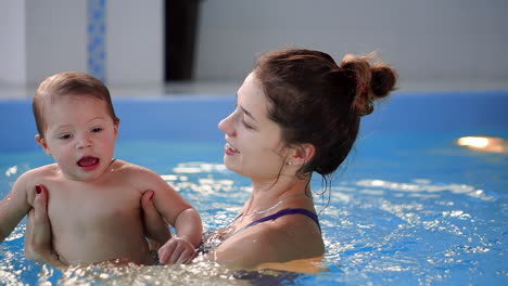 familia sana madre enseñando al bebé piscina de natación