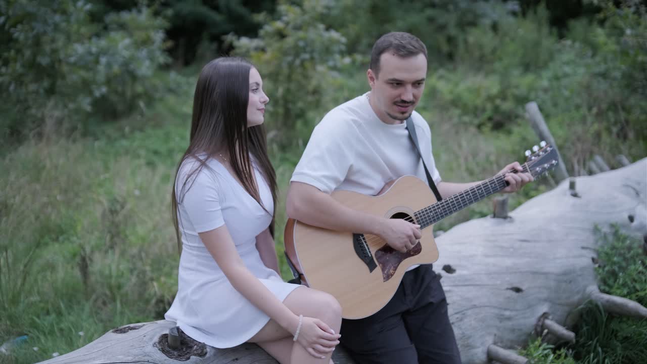pareja tocando la guitarra al aire libre