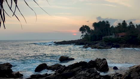 scenic coastal view of white frothy waves rolling into bay with rocky shoreline during sunset in southern province sri lanka