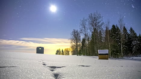 Zeitraffer-Von-Mond-Und-Sternenhimmel,-Der-Sich-über-Verschneite-Nordische-Landschaft-Und-Wald-Mit-Fasssauna-Und-Hütte-Bewegt