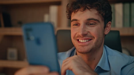 happy employee looking mobile phone receiving notification at night home closeup