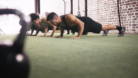 Tres-Personas-Haciendo-Flexiones-En-El-Gimnasio