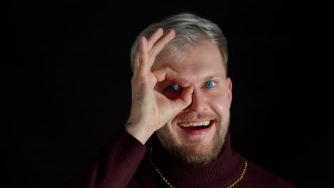 man smiling and looking at camera with okay sign gesture