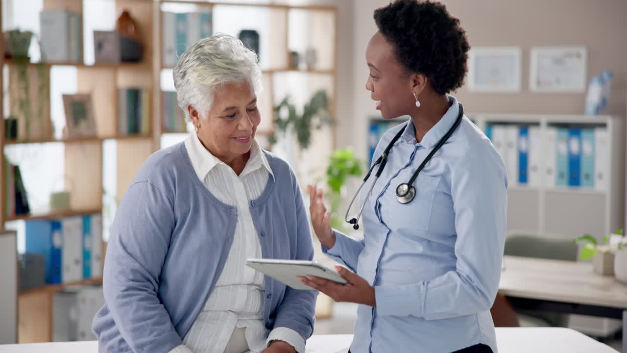 Doctor consulting with elderly patient using a tablet