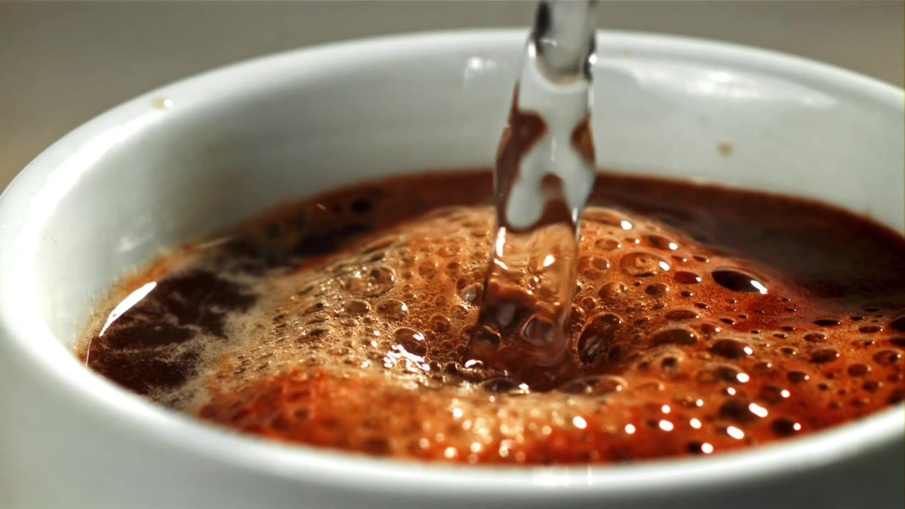 Versare acqua calda in una tazza di caffè