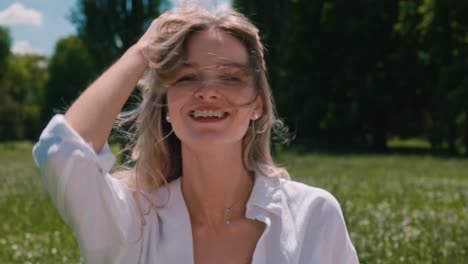 a young and pretty woman posing for the camera in the park whilst having a picnic and enjoying their company