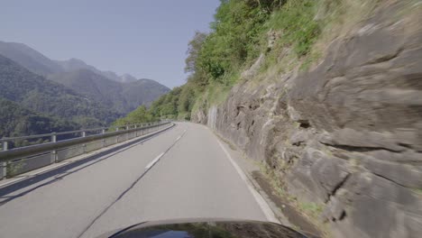 Driving-on-a-narrow-mountain-road-in-a-forest-in-the-Italian-Alps