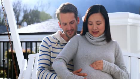 pregnant couple sitting in swing 4k