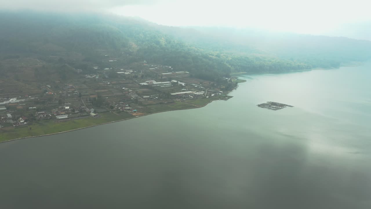 Aerial video; Drone view of a lakeside city surrounded by jungle