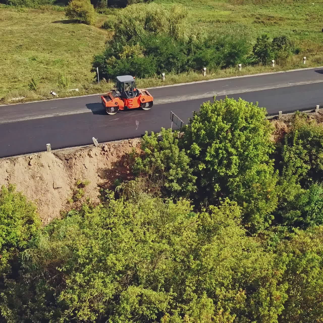 Aerial view. Laying a new asphalt on the road. Road repair machine with heavy vibration roller compactor