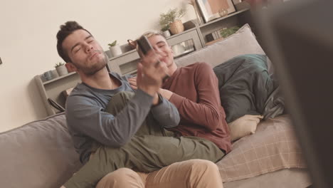 two young watching concert on tv and singing along