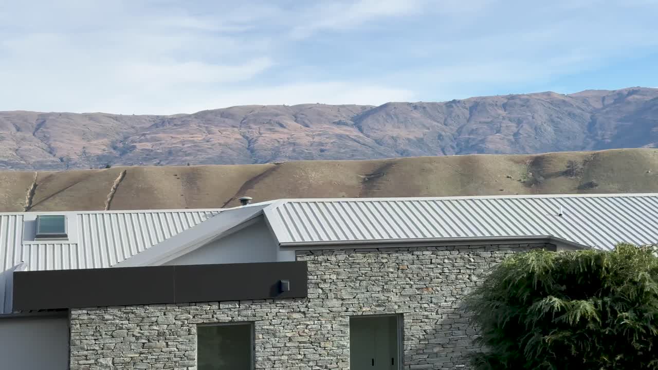 A serene drive through Cromwell, New Zealand, showcasing autumn foliage, distant hills, and tranquil lakeside views under soft daylight