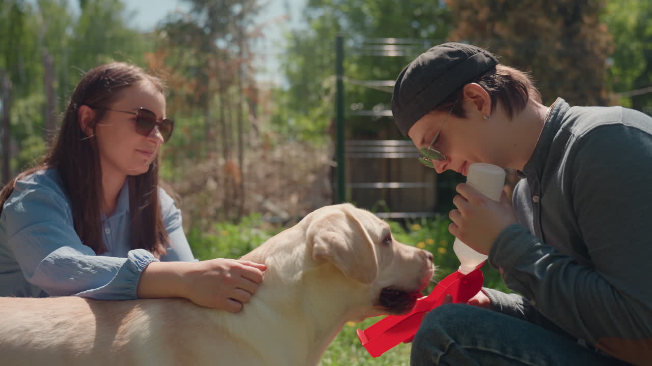 야외에서 반려견과 함께 여가를 보내는 커플, 래브라도견과 함께 야외에서 식사를 즐기는 편안한 커플, 반려동물견과 함께 야외에서 평화롭게 피크닉을 즐기는 친구 커플