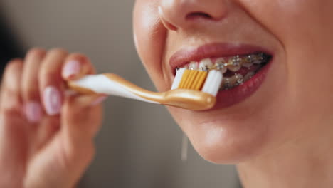 mujer cepillándose los dientes con aparatos dentales