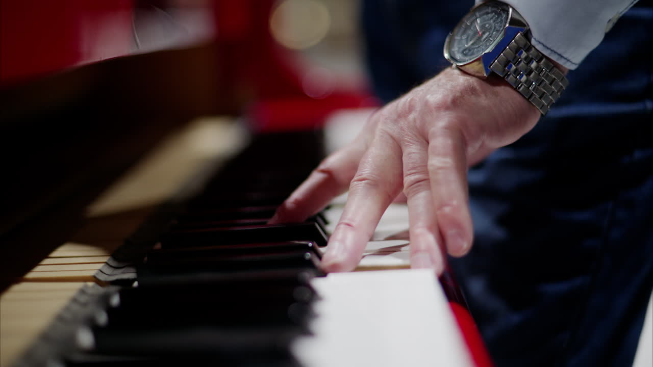 Close up of a man playing a red piano