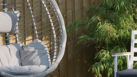 summer garden scene showing swing chair, garden chair and bamboo plants on a summers day