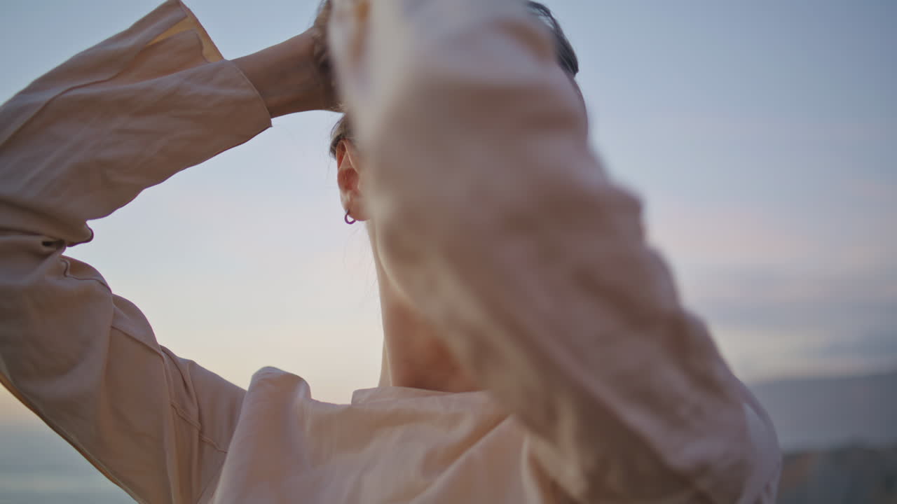 야외에서 자연을 즐기며 일몰을 포즈로 하는 감각적인 여성. 카메라를 찾는 소녀