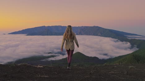woman approaches viewpoint spreading her arms and embracing the sunset beauty