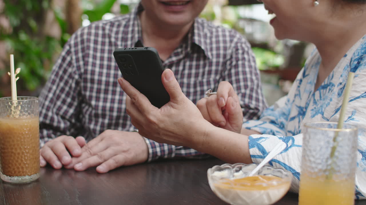 Aged Spouses Learning to Take Photos on Smartphone in Cafe