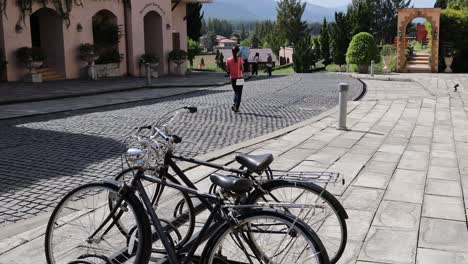 people walking by parked bicycles in a plaza