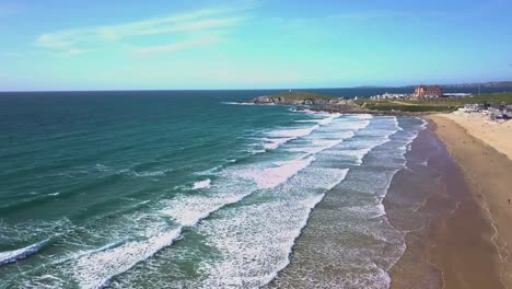 Große-Drohnenaufnahme-Von-Surfern,-Die-Auf-Wellen-Warten,-Während-Sie-Auf-Den-Fistralstrand-Brechen