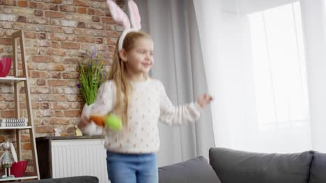 video de una chica con orejas de conejo saltando en el sofá