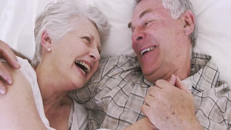 Senior-couple-smiling-in-bed