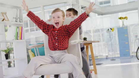 boy as business executives pushing his colleague on chair 4k