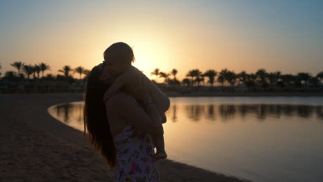 happy mom and son enjoying holiday on sea beach. cheerful woman throwing up boy.